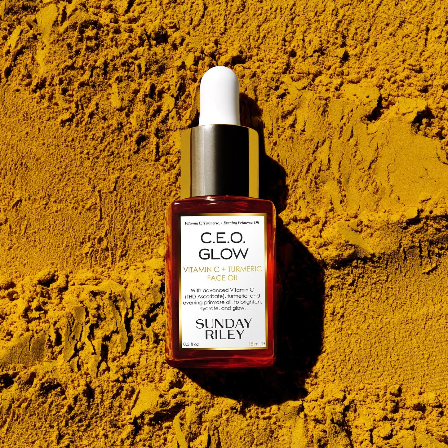 C.E.O. Glow Face Oil lay down on turmeric powder