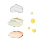 Three swatches arrayed horizontally on a completely white background.  From top to bottom, white creamy swatch of CEO Serum, light yellow creamy swatch of Auto Correct and an orange creamy swatch of CEO Rich Hydration Cream.  To the right of them, four drops of yellowish orange CEO Glow oil of differing sizes.
