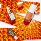 C.E.O. Glow, C.E.O. Serum, Auto Correct and C.E.O. Cream bottles over a orange reflective ribbon on white background
