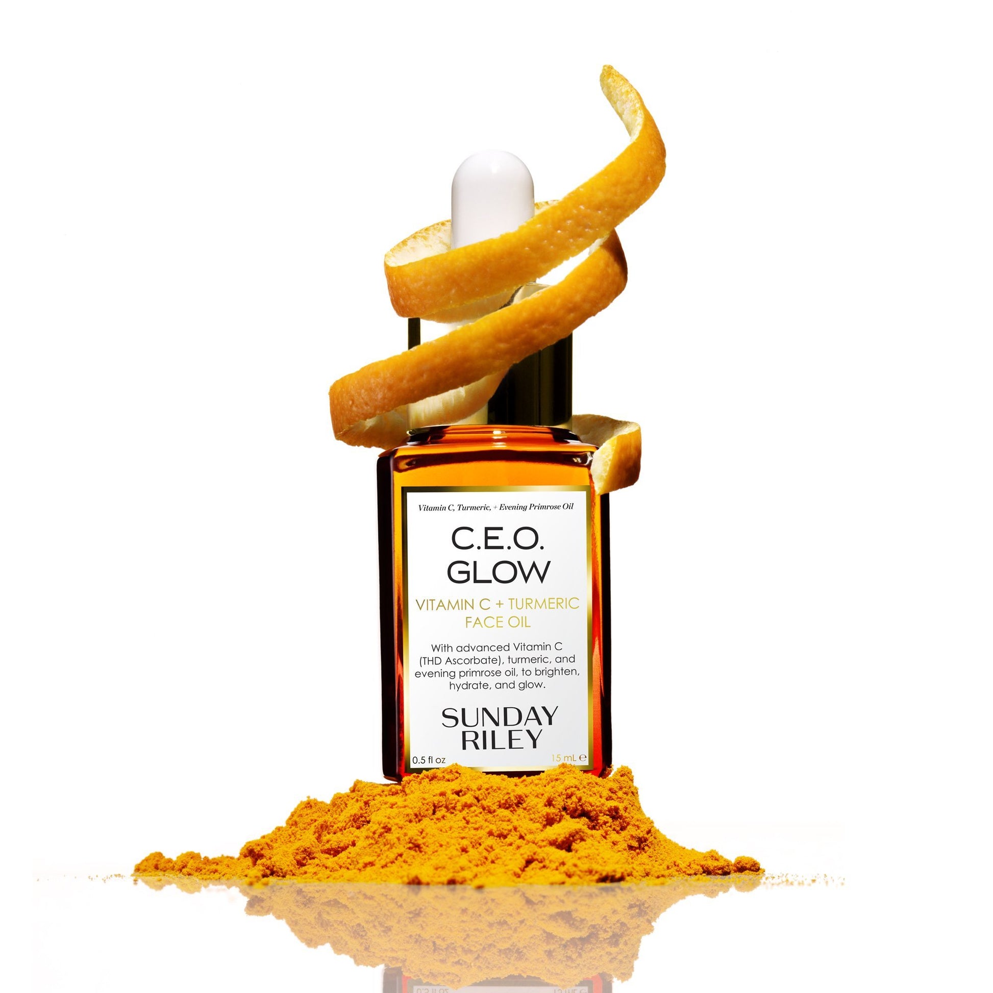 C.E.O. Glow Face Oil in a orange gradient glass bottle with an orange slice wrapped around the silicon dropper top and orange powder in front of bottle..