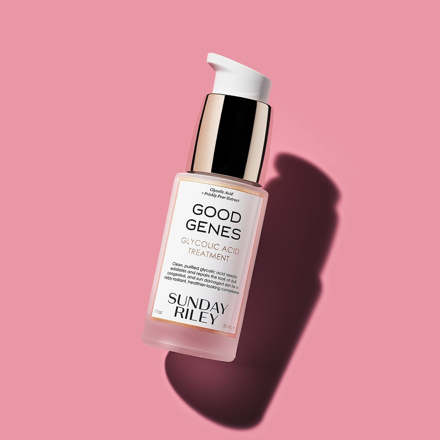 Good Genes Glycolic bottle lay down on a pink background with shadow
