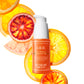 C.E.O. Vitamin C Serum bottle over citric fruits slices on a white background