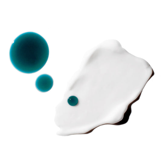 Three blue drops of Luna and white swatch of Good Genes Glycolic on a white background